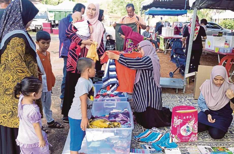   Pengunjung tidak melepaskan peluang memilih barangan yang dijual di  Bazar Jualan Amal Garaj dan Bonet Kereta Badan Kebajikan Pejabat Daerah Kubang Pasu, semalam. 