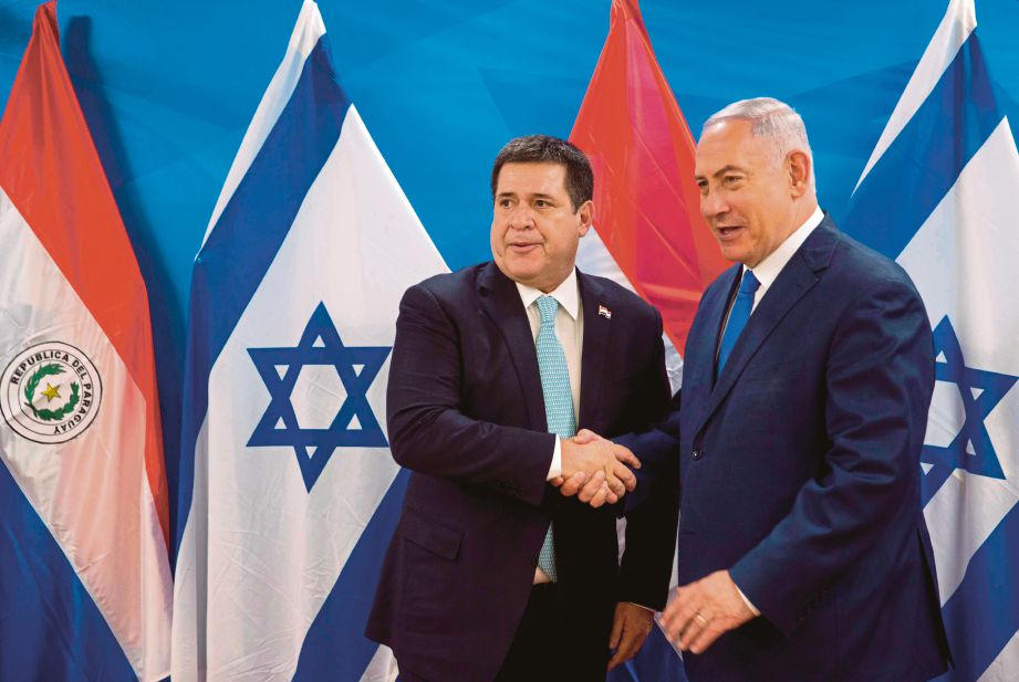 Benjamin Netanyahu (kanan) berjabat tangan dengan Horacio Cartes ketika pertemuan mereka di pejabat Perdana Menteri di Jerusalem. - AFP