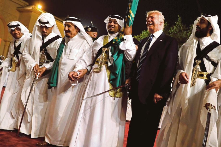 TRUMP menyertai pembesar Arab Saudi melakukan tarian pedang ketika upacara menyambut ketibaannya di Istana Al Murabba, Riyadh, kelmarin.  - Reuters,
