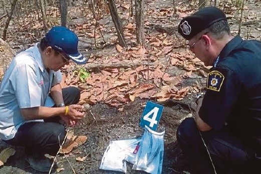 ANGGOTA polis memeriksa serpihan tulang yang dipercayai mangsa bunuh ditemui di satu kawasan hutan di Udon Thani.