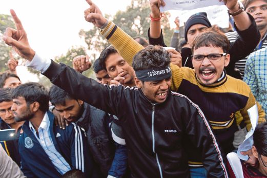PENUNJUK perasaan laungkan slogan membantah pembebasan perogol juvana itu di New Delhi, semalam.