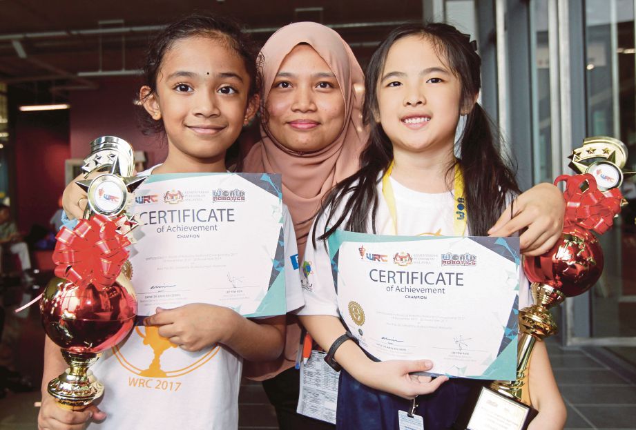  Norliyana Natasya   bersama  Dmisha  (kiri) dan Nur Elyshia  yang menjuarai ketegori junior dalam  Pertandingan World Robotics Championship, kelmarin.