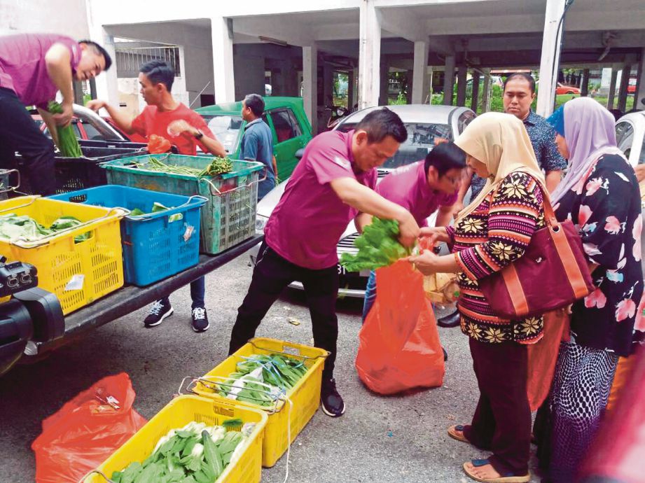  Sukarelawan AIXIN memberi sayur-sayuran secara percuma kepada penduduk di Flat Cengal di Kulai.    