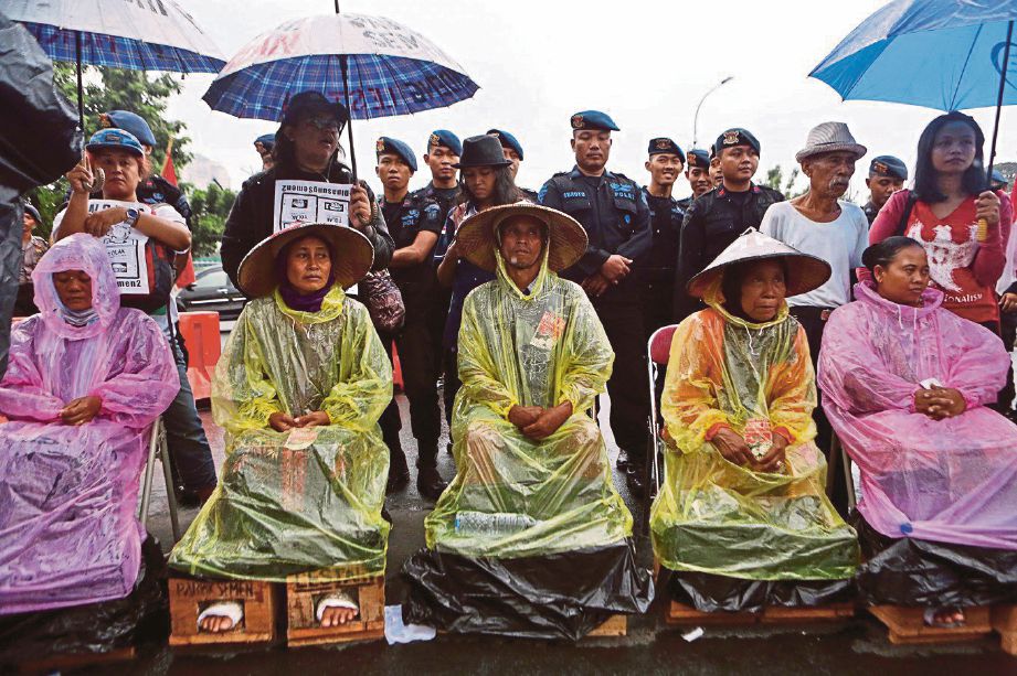 SEKUMPULAN petani dari Gunung Kendeng di Jawa Tengah yang menanam kaki mereka dalam blok simen ketika menyertai tunjuk perasaan   di hadapan Istana Presiden di Jakarta sejak 17 Mac lalu. - JP