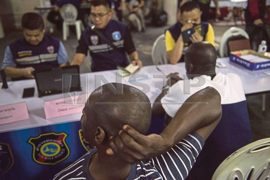  DUA lelaki warga Afrika yang ditahan untuk siasatan dalam operasi di daerah Nana di Bangkok, Thailand baru-baru ini. - AFP