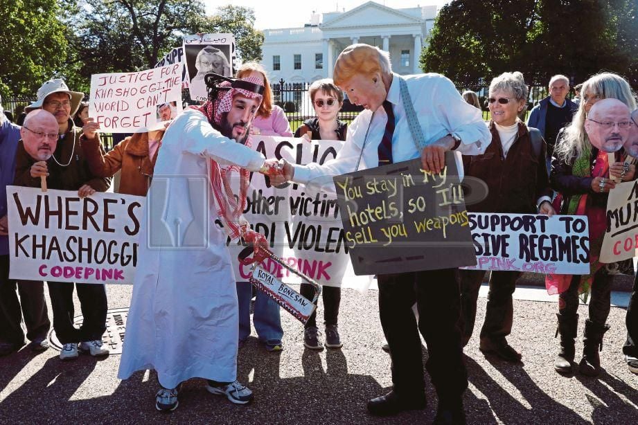 AKTIVIS berpakaian sebagai Putera Mahkota Saudi Mohammad bin Salman dan Presiden Amerika Syarikat Donald Trump bersalaman ketika demonstrasi menyeru sekatan terhadap Arab Saudi serta membantah kehilangan   Jamal Khashoggi. - Reuters