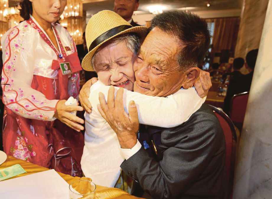 GEUM-seom memeluk anak lelakinya ketika bertemu semula selepas 65 tahun terpisah akibat Perang Korea. - Agensi