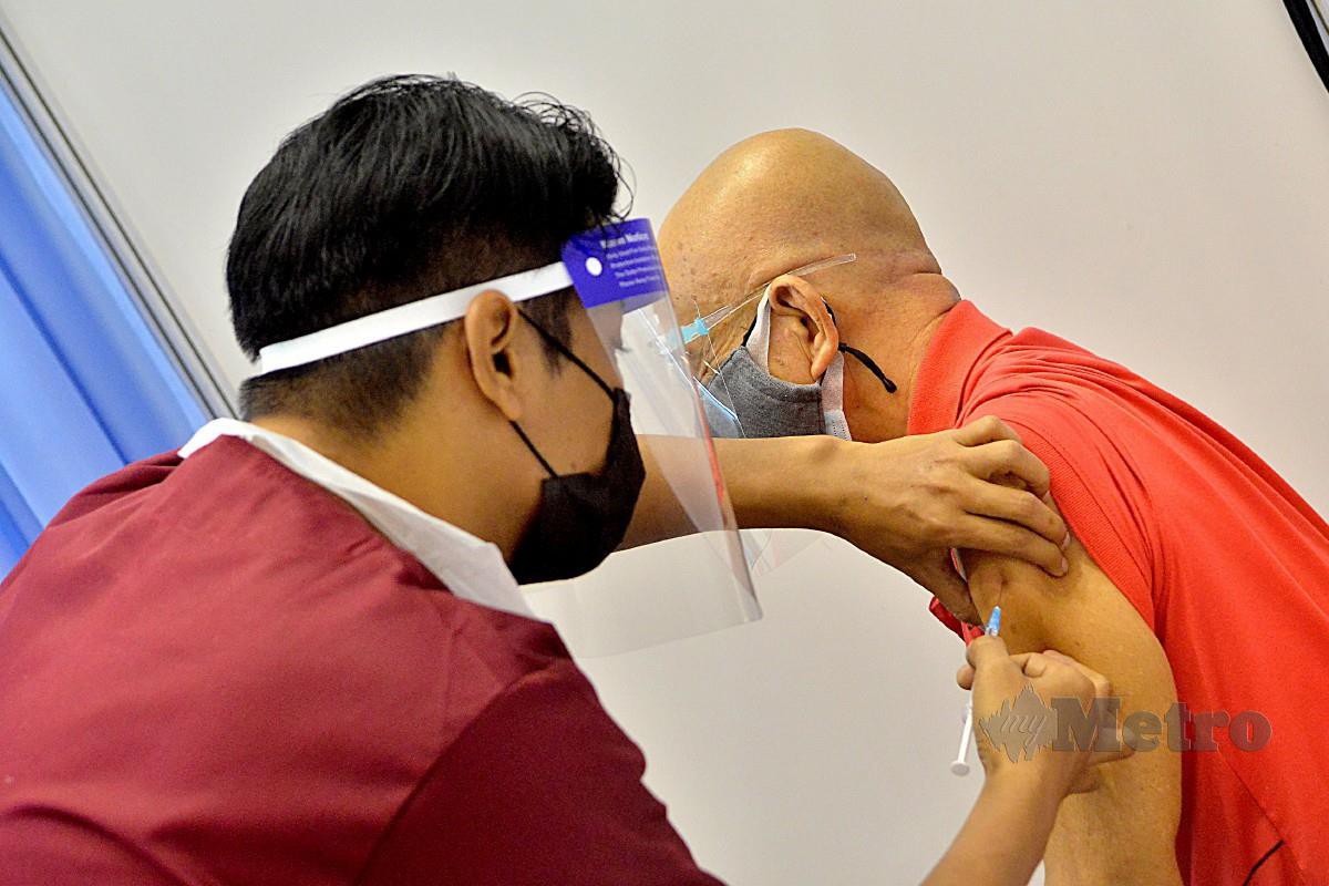 SEORANG warga emas menerima suntikan vaksin di Pusat Pemberian Vaksin Institut Pengajian Tinggi (PPV IPT) Mega di Dewan Agung Tuanku Canselor Universiti Teknologi Mara (UiTM), Shah Alam, semalam.