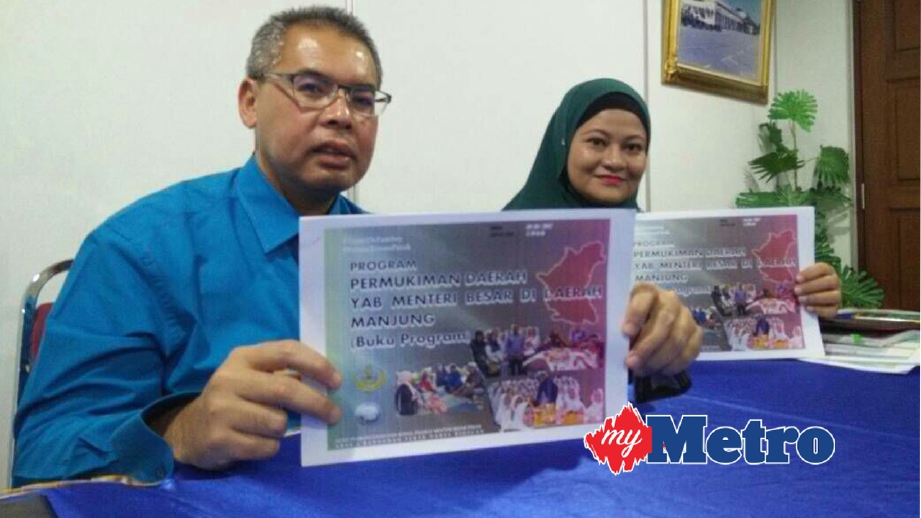 MOHAMAD Fariz (kiri) menunjukkan kertas program sempena Pemukiman Menteri Besar di Daerah Manjung. FOTO Noor Hidayah Tanzizi