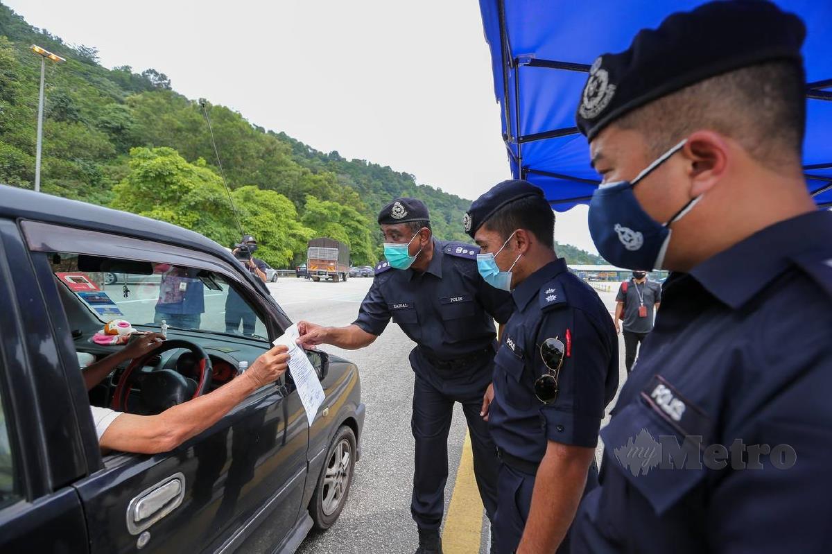 GAMBAR hiasan. Asisten Komisioner Zainal Mohamed Mohamed memeriksa surat kebenaran rentas negeri pada tinjauan di Tol Gombak arah Bentong ke Kuala Lumpur Julai lalu. FOTO ASWADI ALIAS.