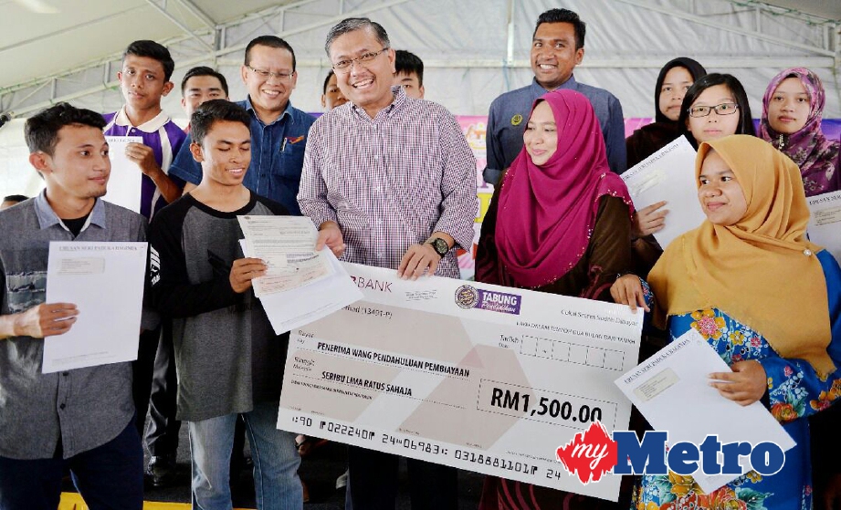 SHAMSUL Anuar (tengah) menyampaikan wang pendahuluan PTPTN kepada penerima dari Parlimen Lenggong, Gerik, Padang Rengas dan Kuala Kangsar. FOTO Razif Rosli