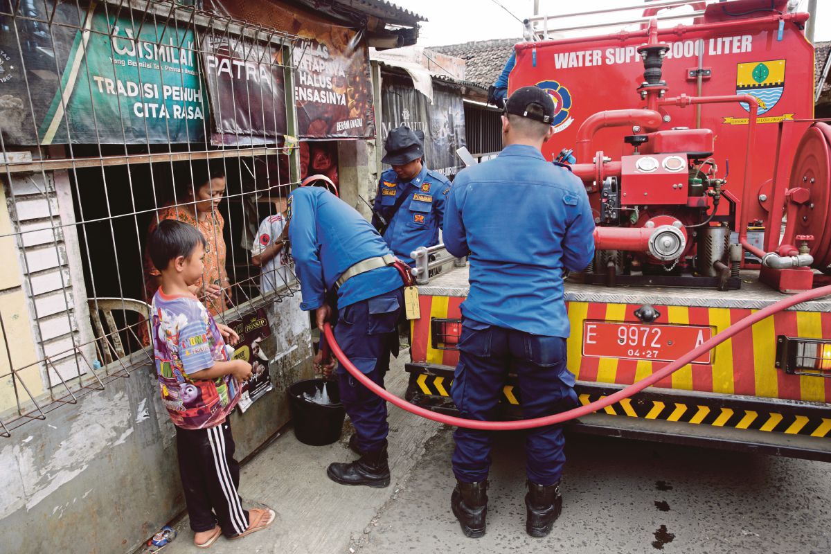 PENDUDUK terjejas susulan gempa bumi di Cianjur, Indonesia menerima bekalan air bersih yang disediakan oleh bomba. FOTO EPA 