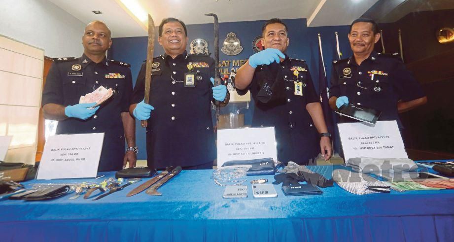 ZAINOL (dua dari kiri) menunjukkan barangan rampasan termasuk parang selepas menahan lima lelaki warga Indonesia dipercayai terbabit dengan 13 kes pecah rumah serta samun di IPK Pulau Pinang, semalam.