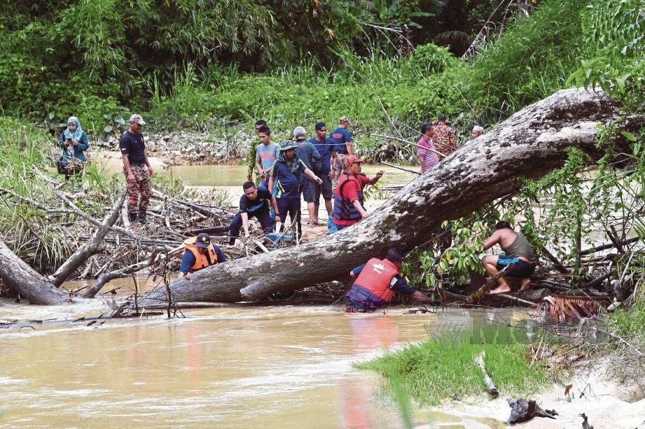 ANGGOTA penyelamat dibantu penduduk kampung menghilir sungai mencari mangsa lemas berhampiran pintu air Tanjung Sik di Kampung Charuk Kit berhampiran Balai Polis Sik, kelmarin.