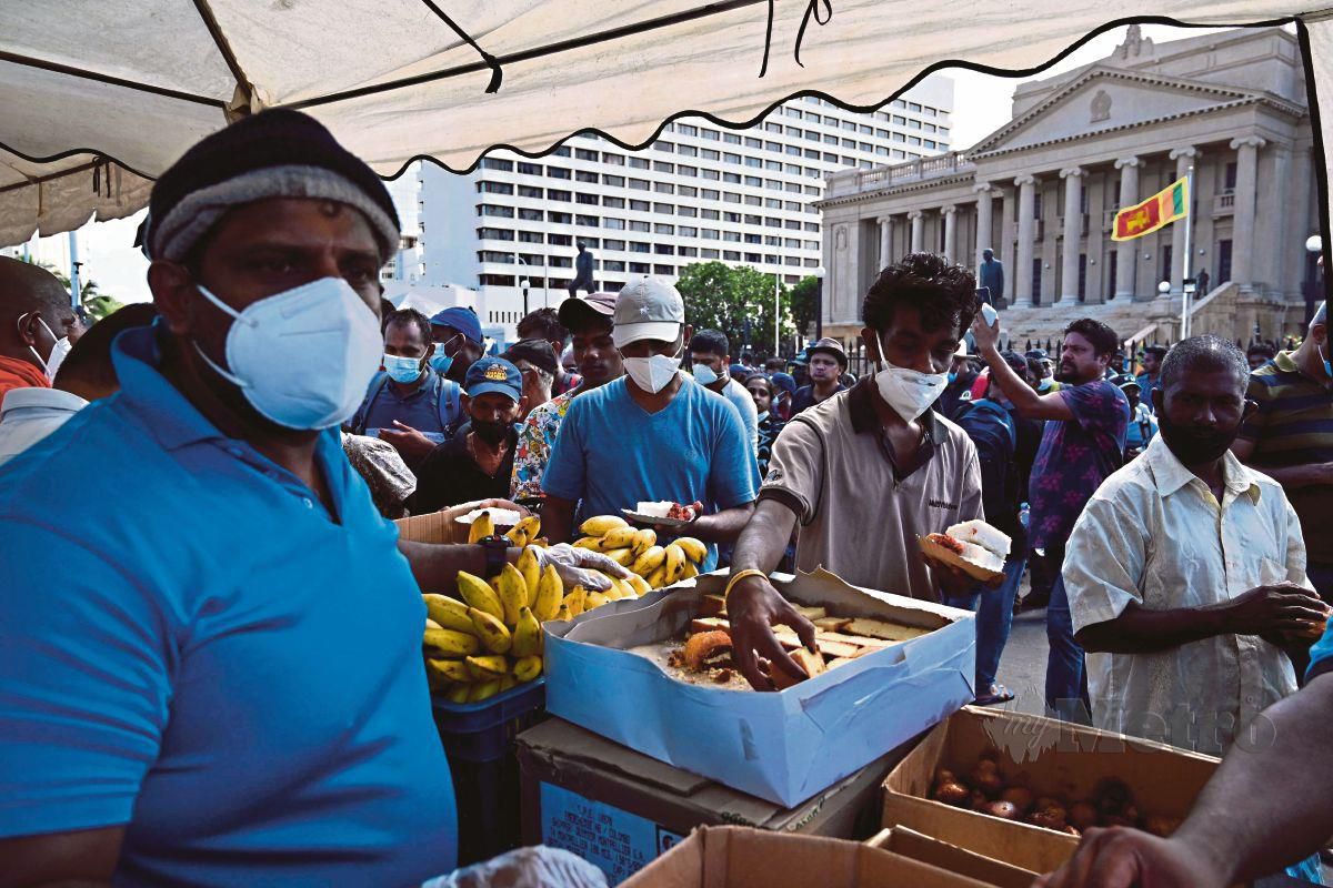PENUNJUK perasaan mendesak peletakan jawatan Presiden Sri Lanka mengambil makanan yang disediakan. Krisis makanan dan bahan api mendorong demonstrasi besar-besaran di seluruh negara. FOTO AFP
