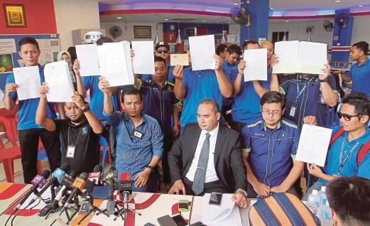 ZULKALNAIN (duduk dua dari kiri) bersama staf syarikat penerbangan Rayani Air menunjukkan laporan polis.