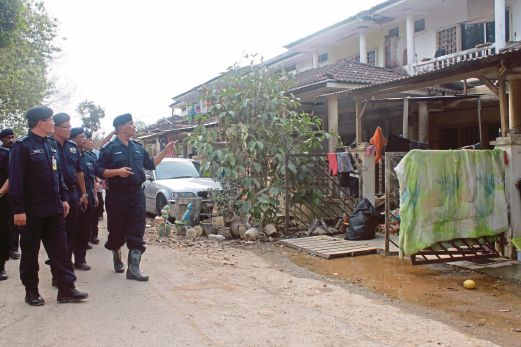 NOOR Rashid (kanan) diiringi Mazlan (kiri) meninjau kawasan Perumahan Polis yang dipenuhi lumpur selepas banjir. 