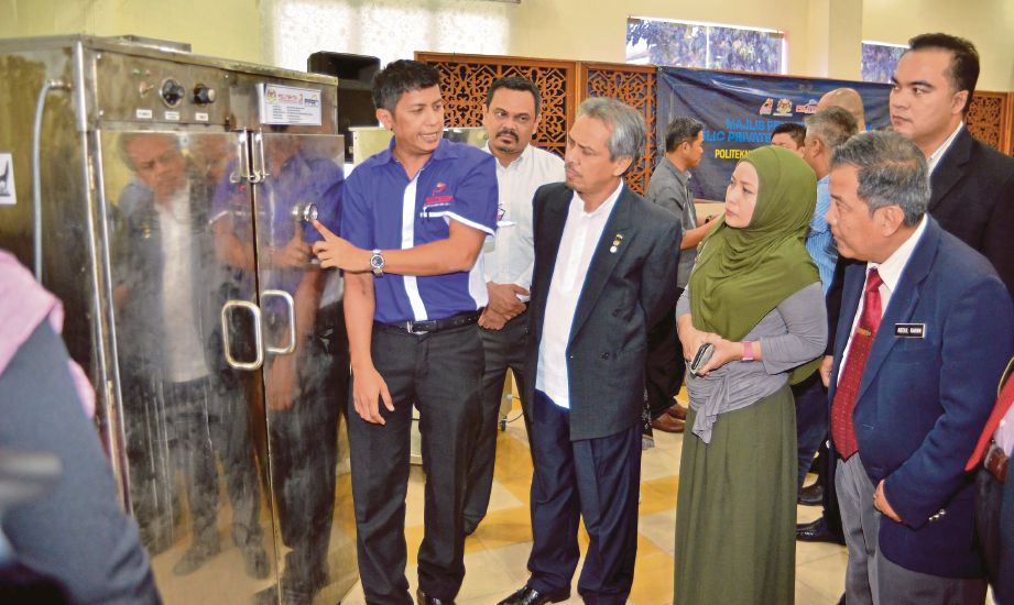 ABDUL Rahim (tiga dari kiri) melihat Multipurpose Smoke Machine pada majlis penyerahan produk PPRN.