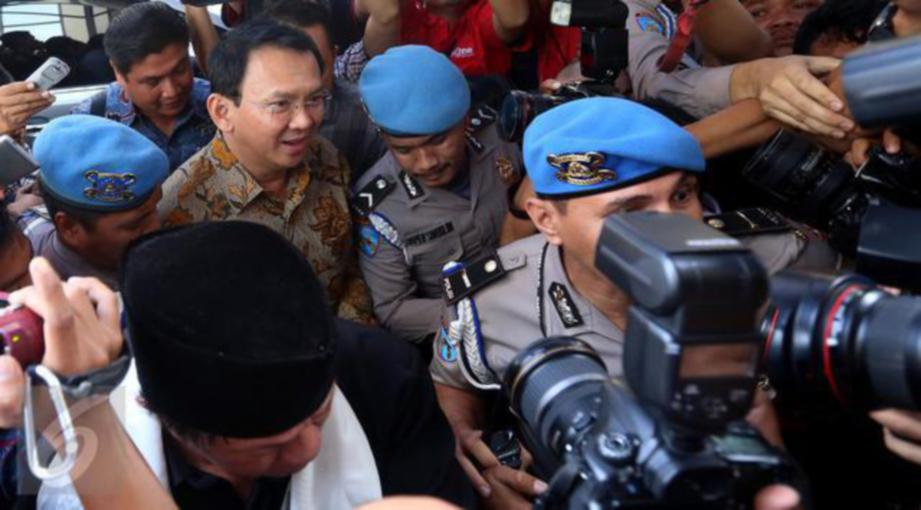 AHOK (tengah) dikawal ketat ketika tiba di ibu pejabat polis Jakarta, semalam. - Antara  