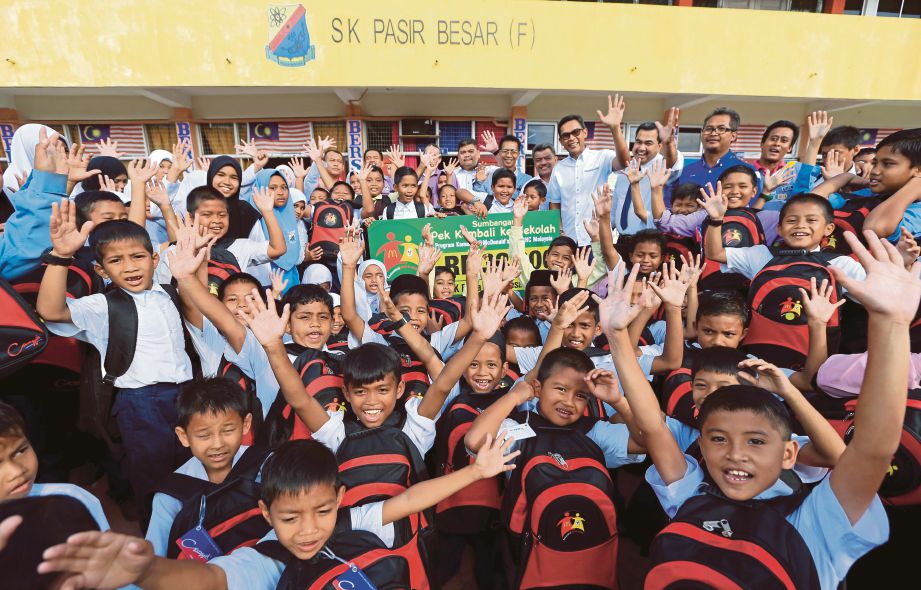 MURID SK FELDA Pasir Besar bersorak selepas menerima bantuan persekolahan masing-masing.