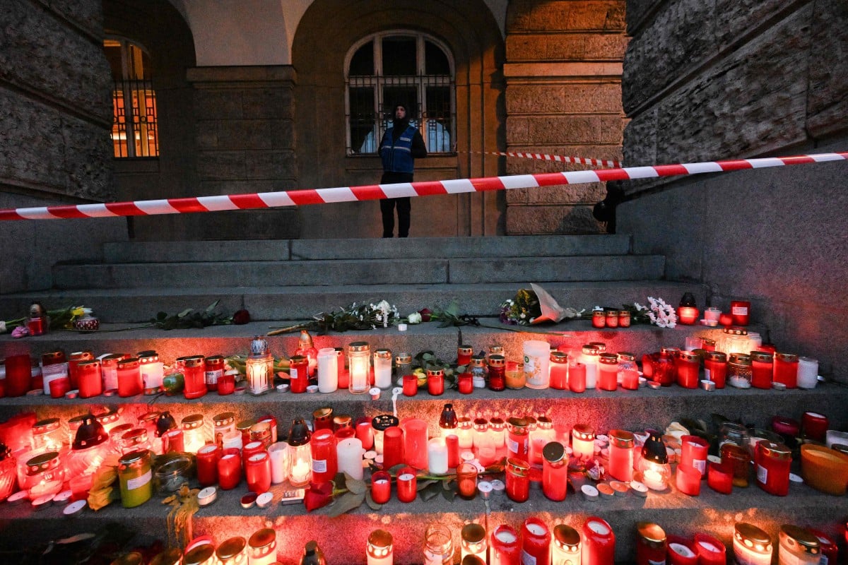 PASUKAN keselamatan berkawal di luar Universiti Charles, Republik Czech yang dipenuhi lilin dan bunga sebagai penghormatan terhadap 14 mangsa tembakan. FOTO AFP.