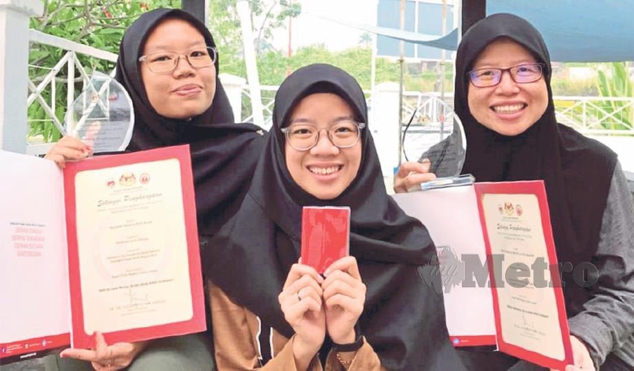 NATASHA (kiri) bersama Nuraina dan ibu mereka, Nur Faradiana menunjukkan sijil penghargaan sebagai penderma darah.