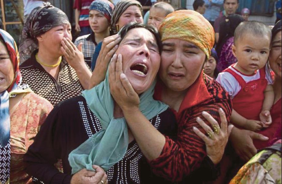 WANITA Uyghur di Xinjiang meratapi ahli keluarga yang ditahan pihak berkuasa China ketika satu protes pada Julai 2009. - Fail (Agensi)