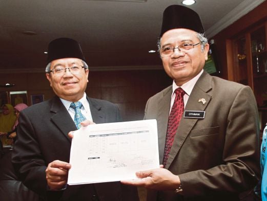   OTHMAN  (kanan) dan   Mohd Nordin   menunjukkan keputusan  UPKK  2014 di Putrajaya, semalam.  