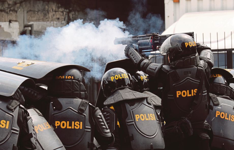 ANGGOTA polis antirusuhan melepaskan gas pemedih mata ke arah kumpulan penunjuk perasaan. FOTO EPA