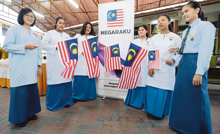  PELAJAR  mengibarkan Jalur Gemilang ketika menyanyikan lagu Aku Negaraku di SMK Damansara Utama, Kuala Lumpur.