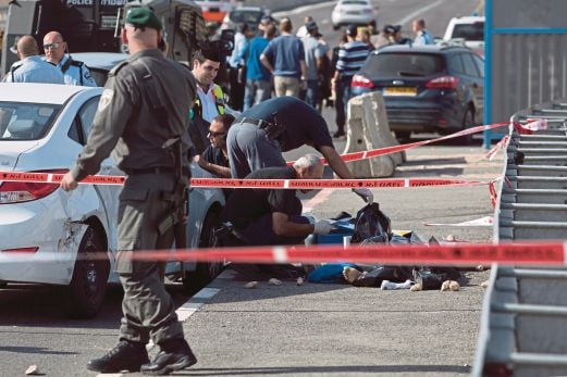 POLIS Israel memeriksa mayat seorang pemandu teksi Palestin yang mati ditembak selepas merempuh orang awam.