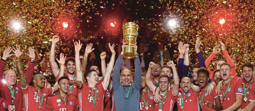 GUARDIOLA (tengah) menjulang Piala Jerman bersama anak buah.