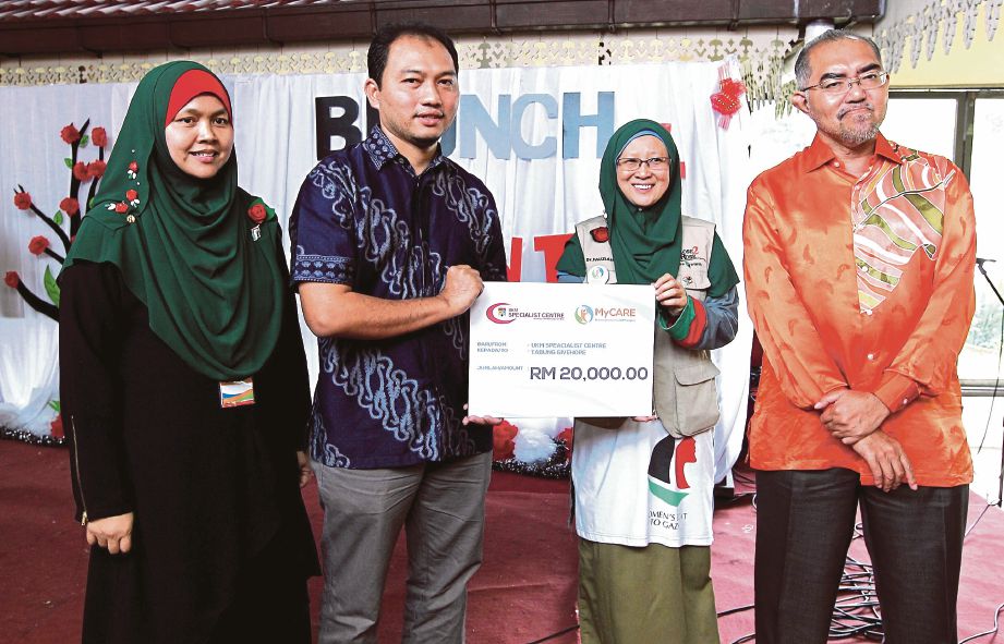 Ketua Pembangunan dan Perniagaan Pusat Pakar UKM, Hassan Basri Isa  (dua dari kiri) menyerahkan cek bernilai RM20,000 kepada Dr Fauziah  pada majlis sarapan amal di Restoran Nelayan Gombak.  