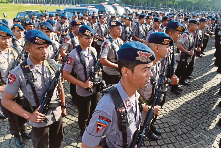 ANGGOTA polis Indonesia mengadakan perbarisan di Monumen Nasional, Jakarta, sebelum mereka memulakan tugas menjaga keselamatan menjelang sambutan Krismas dan Tahun Baru, semalam.  - AP 