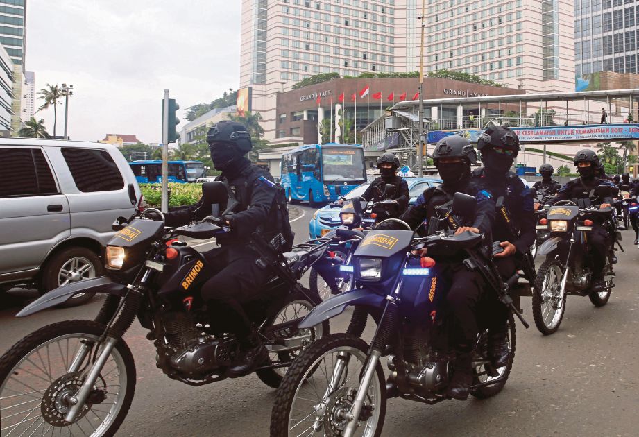 BEBERAPA anggota polis bermotosikal meronda di satu kawasan perniagaan menjelang sambutan Krismas dan Tahun Baru di Jakarta. - Reuters