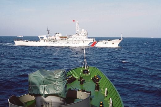 GAMBAR  fail menunjukkan kapal pengawal pantai China (atas) hanya beberapa meter dari kapal Tentera Laut Vietnam di Laut China Selatan.
