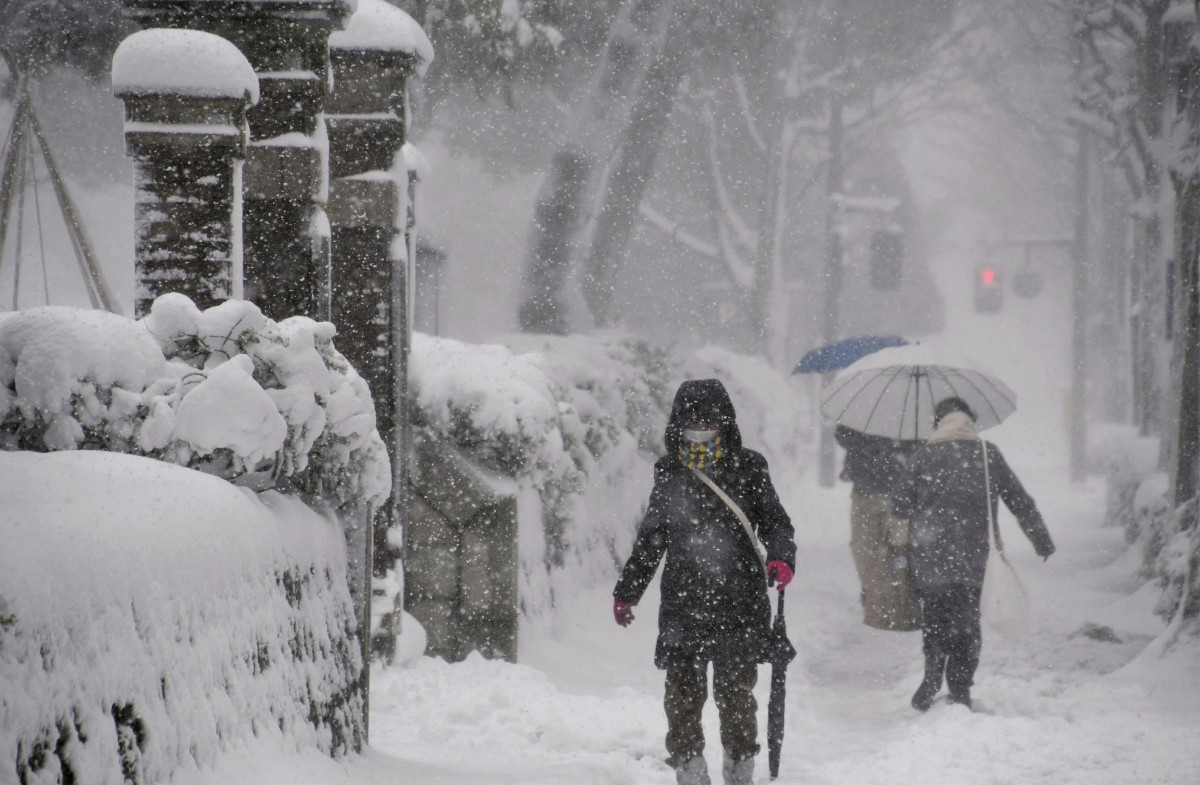 PENDUDUK berjalan dalam salji lebat Kanazawa, wilayah Ishikawa, tengah Jepun. FOTO Kyodo/Reuters.