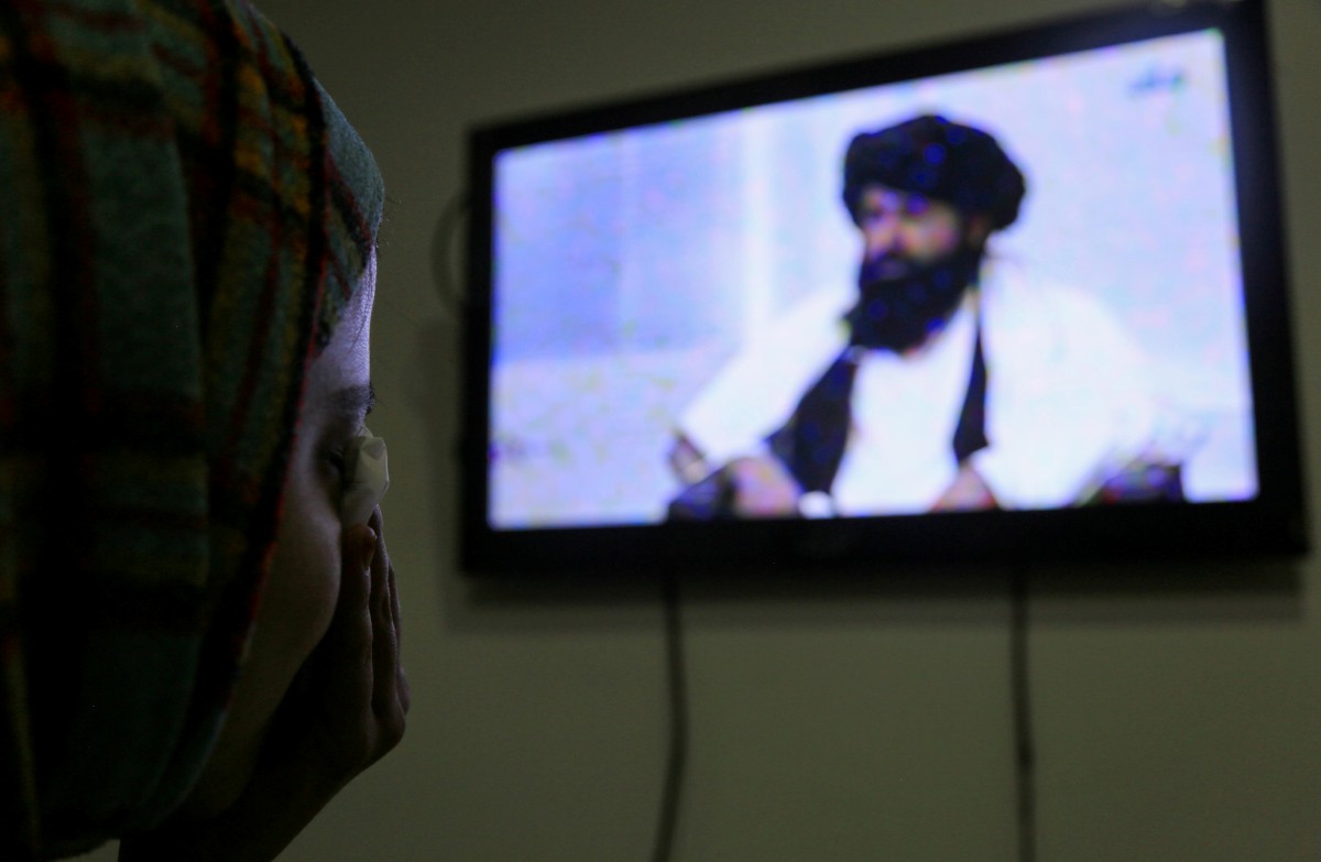 SEORANG gadis mendengar ucapan Nida yang ditayang stesen televisyen Afghanistan, semalam. FOTO EPA.