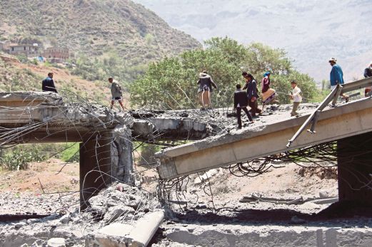 PENDUDUK Yaman berdiri di jambatan yang runtuh selepas serangan udara yang diketuai Arab Saudi berhampiran Ibb, tengah negara itu.  