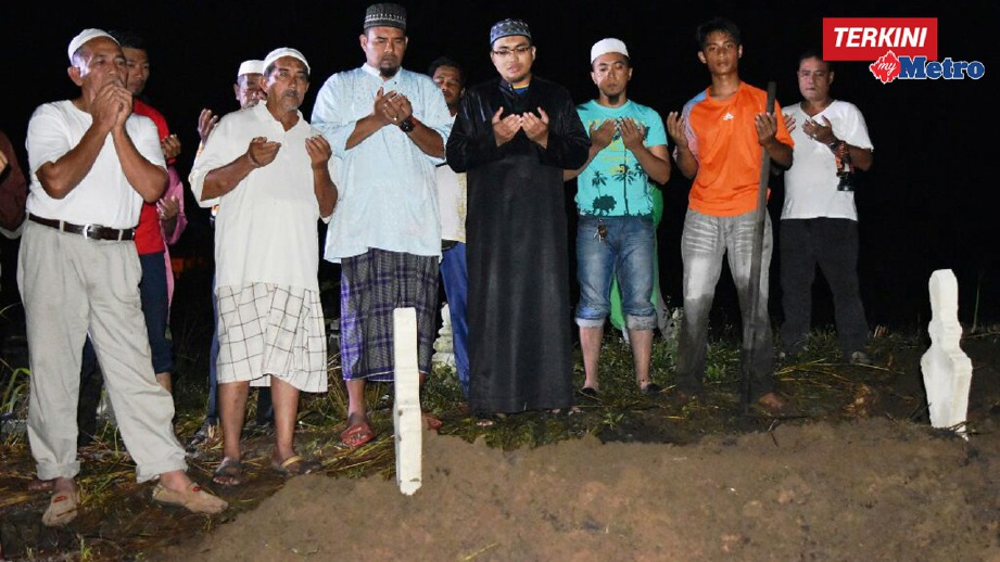 AHLI keluarga Wan Suhana berdoa selepas selesai pengebumian di Tanah Perkuburan Islam Kampung Serating. FOTO Rosli Ilham