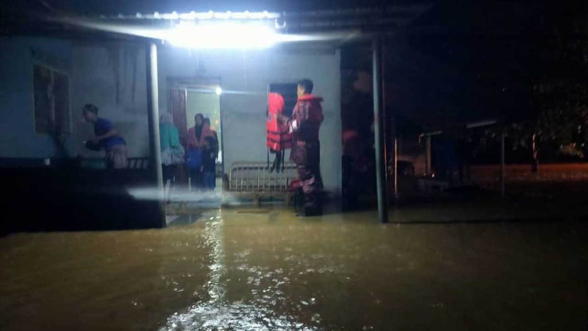 ANGGOT bomba membantu penduduk kampung Repoh, Tanah Merah, untuk berpindah ke PPS susulan kampung itu dilanda banjir. FOTO  ihsan Bomba