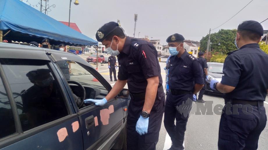 SULIZMIE (depan) melakukan pemeriksaan terhadap pemandu kenderaan di Jalan Besar Tanjung Malim. FOTO Rosman Shamsudin