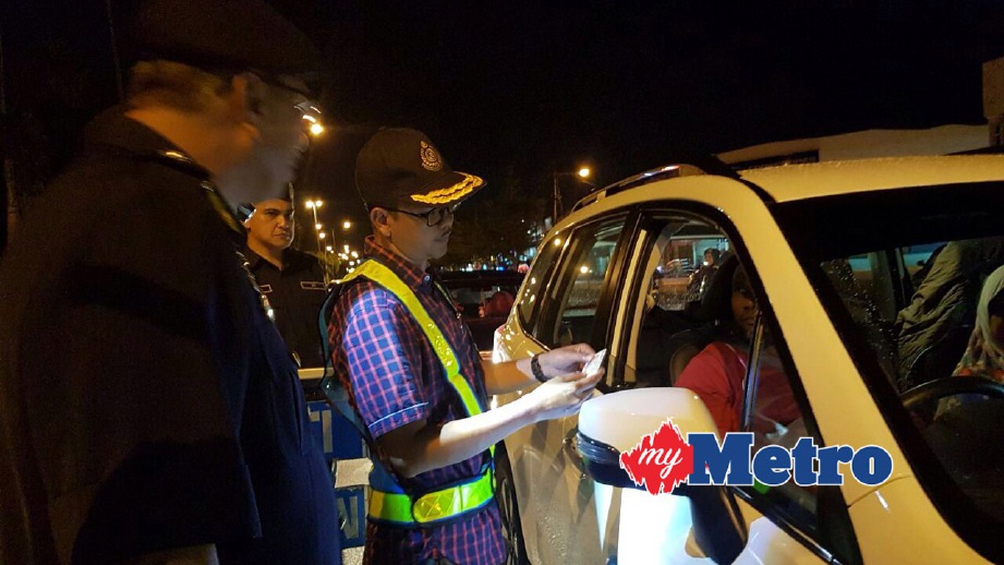 MOHD Zawawi (tiga kiri) memeriksa lesen memandu dalam Ops Rentas Sempadan di Kilometer 3 Jalan Sitiawan-Lumut. FOTO Noor Hidayah Tanzizi
