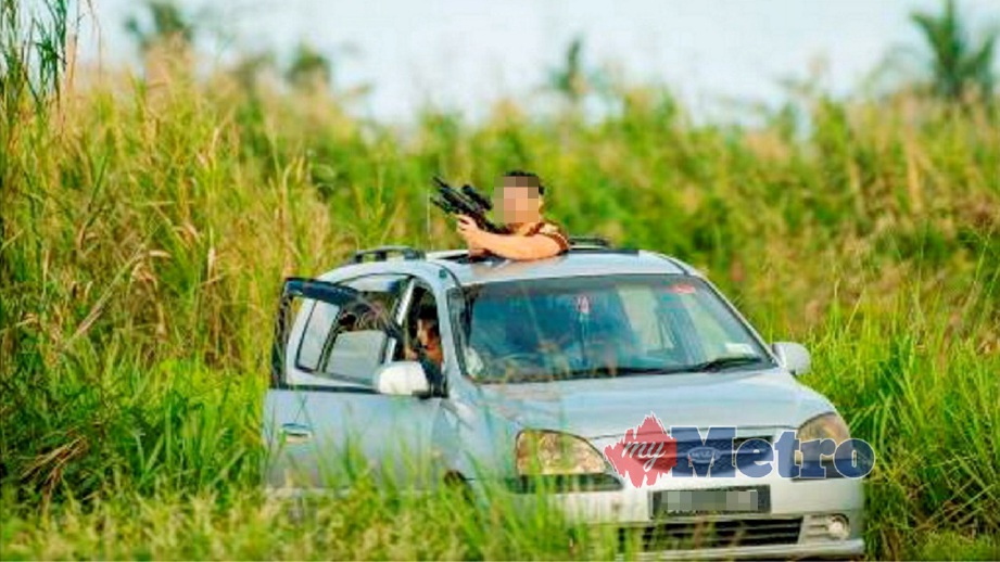 GAMBAR guru lelaki memegang senjata dipercayai digunakan untuk menembak burung yang tular di Facebook. FOTO ihsan Polis