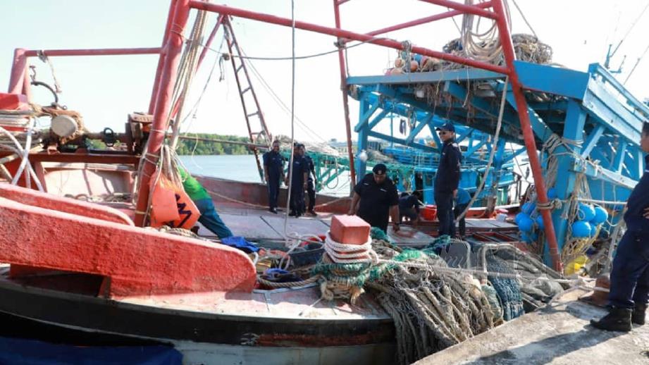 ANGGOTA Bahagian Perlindungan Sumber Jabatan Perikanan Pahang mengawal dua bot pukat tunda nelayan Vietnam yang dirampas ketika menangkap ikan di perairan Pekan. FOTO Mohd Rafi Mamat