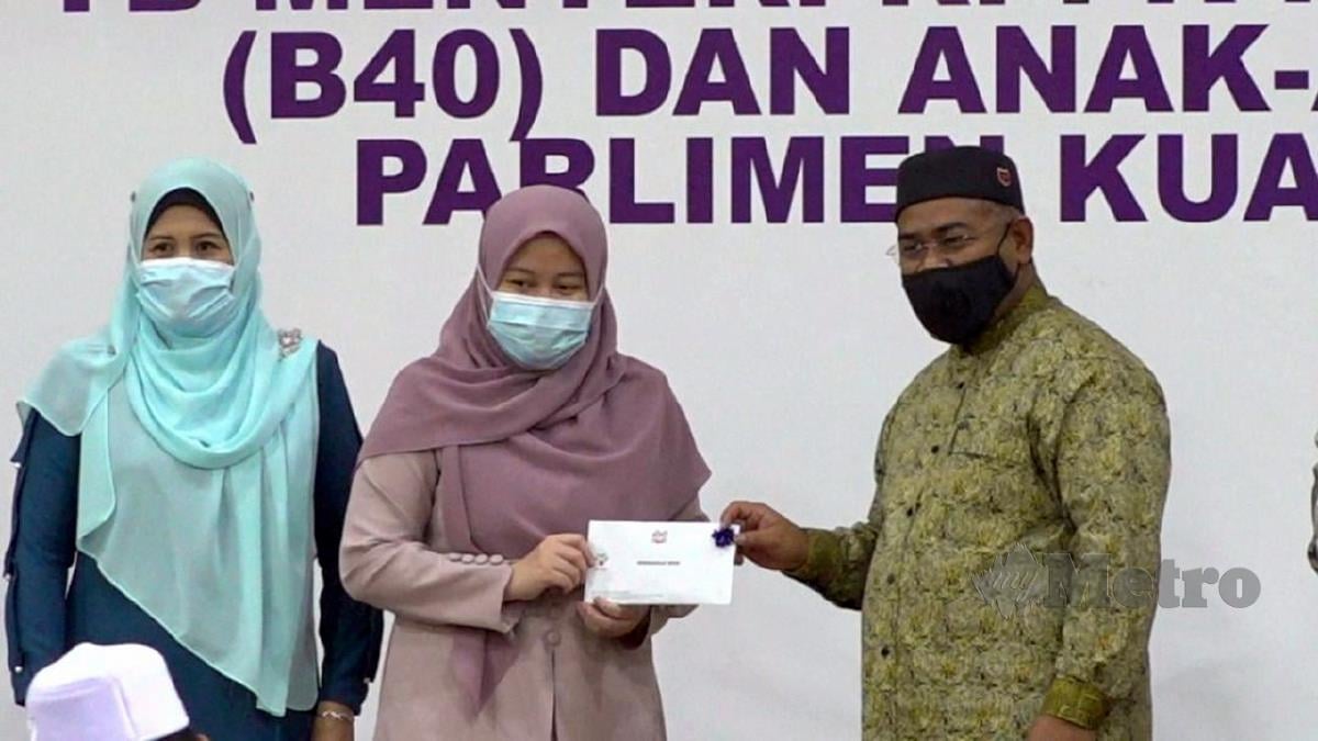 MOHD Khairuddin (kanan) menyampaikan sumbangan ketika Program Sumbangan Kepada Asnaf B40 dan anak-anak yatim Parlimen Kuala Nerus. FOTO Zatul Iffah Zolkiply