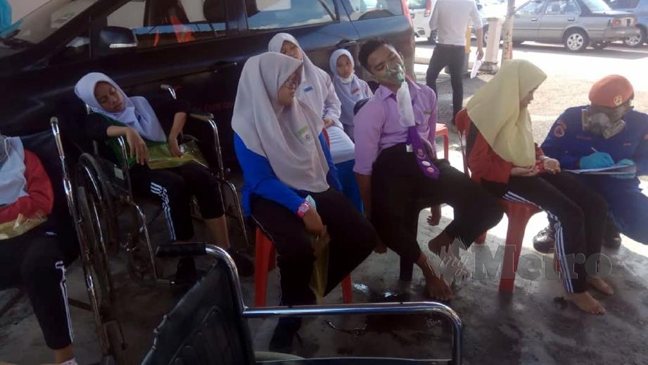 PELAJAR memakai topeng muka sebagai langkah berjaga-jaga ketika menunggu ibu bapa untuk pulang selepas berlaku pencemaran udara di SMK Tanjung Puteri Resort, Pasir Gudang. FOTO Hairul Anuar Rahim