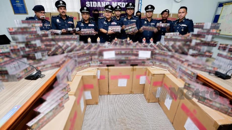 Mohd Rakbi (tengah) menunjukkan sebahagian 15,000 karton rokok seludup dianggarkan bernilai RM240,000 yang dirampas di jeti Pulau Beluru dan tebing Pulau Tongkang. Foto Syamsi Suhaimi