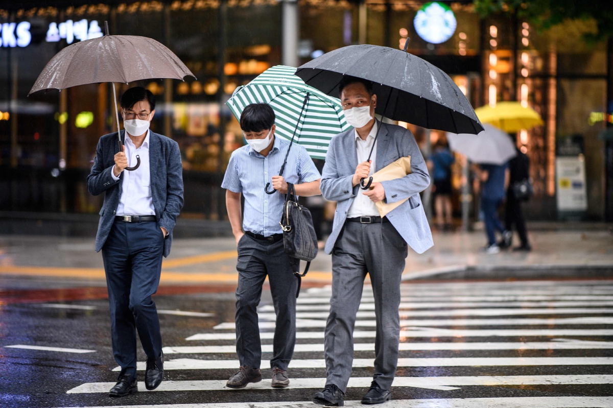 ORANG ramai memakai pelitup muka ketika menyeberangi jalan di Seoul. FOTO AFP 