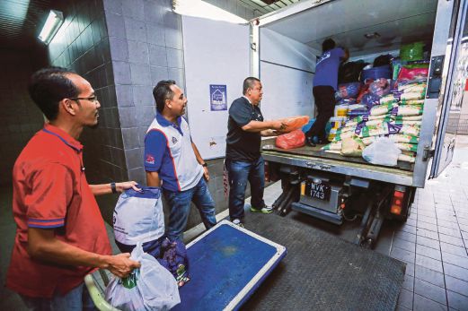 AHLI jawatankuasa TKHM sedang memunggah barang sumbangan  untuk disampaikan kepada mangsa banjir di Bota, Perak.